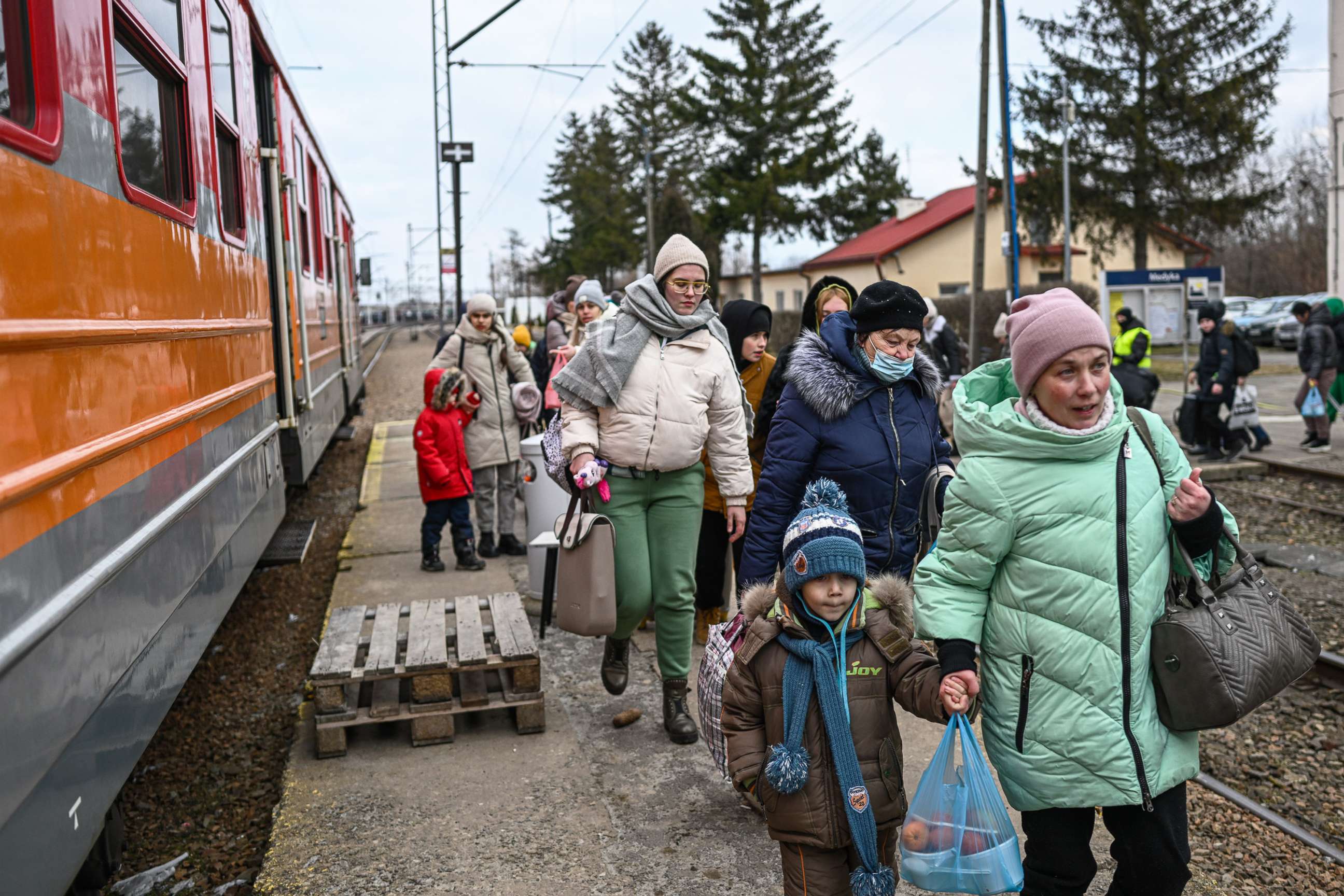PHOTO: Women and children who have fled war-town Ukraine walk to board a train to transport them to Przemysl main train station after crossing the Polish Ukrainian border crossing on March 10, 2022 in Medyka, Poland.