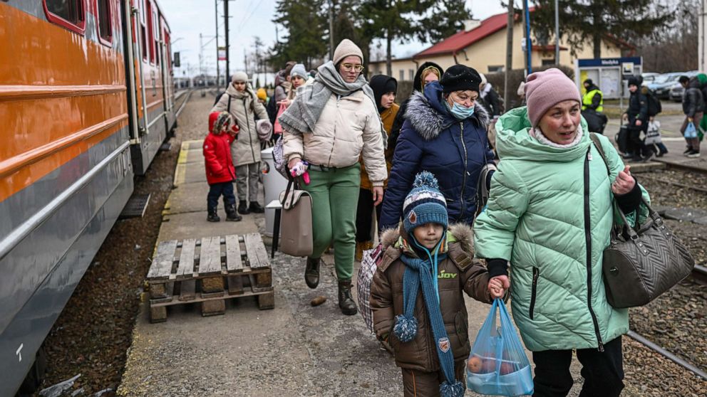 PHOTO: Women and children who have fled war-town Ukraine walk to board a train to transport them to Przemysl main train station after crossing the Polish Ukrainian border crossing on March 10, 2022 in Medyka, Poland.