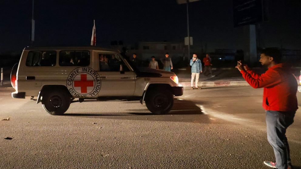 PHOTO: A man takes picture  of International Red Cross vehicles  on Nov. 24, 2023. 