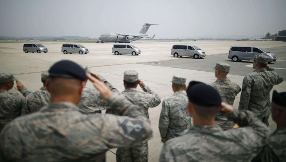 PHOTO: U.S. soldiers salute before vehicles carrying boxes containing remains believed to be of U.S. soldiers who died during the Korean War.