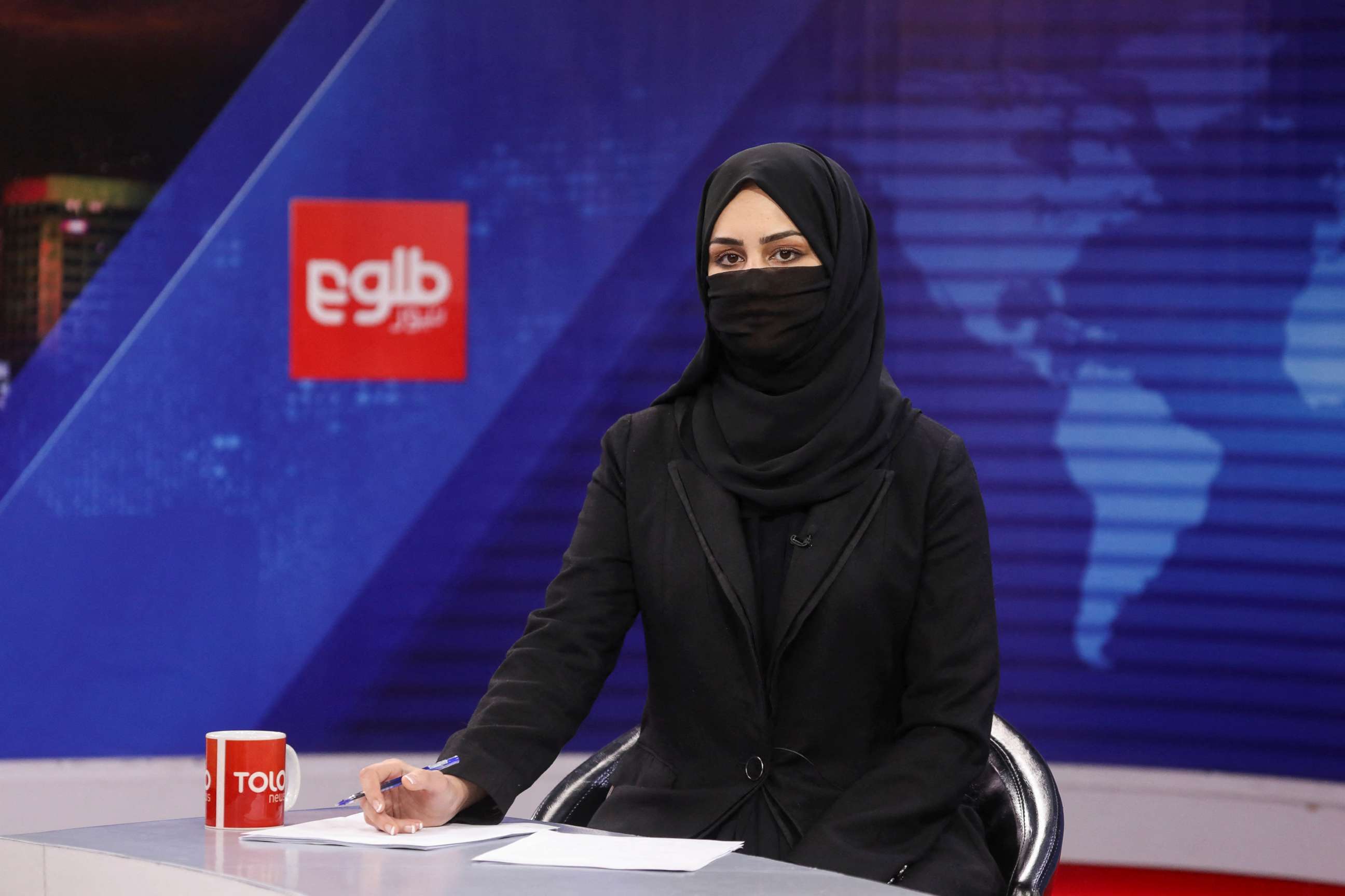 PHOTO: A female presenter for Tolo News, Khatereh Ahmadi, works in a newsroom while covering her face, at Tolo TV station in Kabul, Afghanistan, May 22, 2022.
