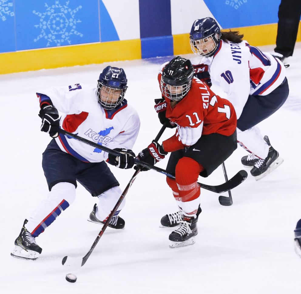 PHOTO: Switzerland's Sabrina Zollinger, center, battles Jong Su Hyon of the unified Korean team for the puck in the preliminary round of women's ice hockey in Gangneung, South Korea, Feb. 10, 2018.