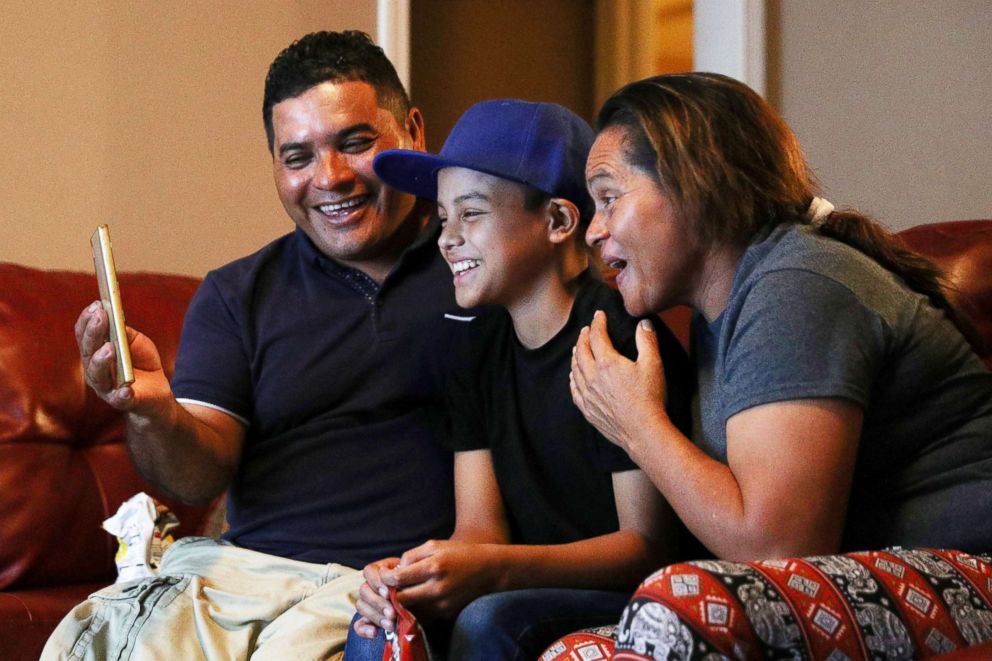 PHOTO: Abisai Montes Marroquin, 11, sits with his father Edward Montes Lopez and mother Maria Marroquin Perdomo while video-chatting with family back in Honduras on their first night together in New Orleans, July 15, 2018.