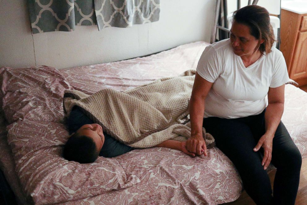 PHOTO: Maria Marroquin Perdomo puts 11-year-old son Abisai to bed on their first night together after being reunited, at La Posada Providencia shelter in San Benito, Texas, July 14, 2018. 