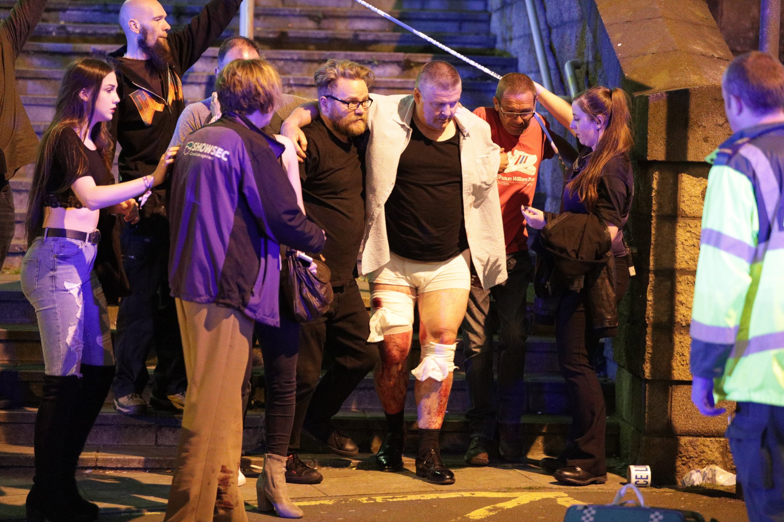PHOTO: People aid an injured man near the Manchester Arena after reports of an explosion, May 22, 2017.