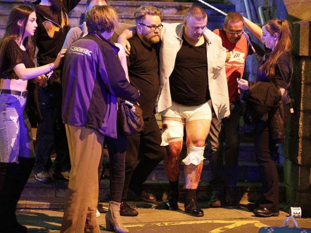 PHOTO: People aid an injured man near the Manchester Arena after reports of an explosion, May 22, 2017.