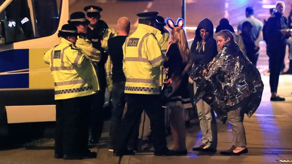 Emergency services personnel speak to people outside Manchester Arena after reports of an explosion at the venue during an Ariana Grande concert in Manchester, England, May 22, 2017.