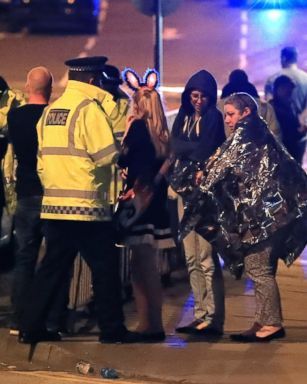 PHOTO: Emergency services personnel speak to people outside Manchester Arena after reports of an explosion at the venue during an Ariana Grande concert in Manchester, England, May 22, 2017.