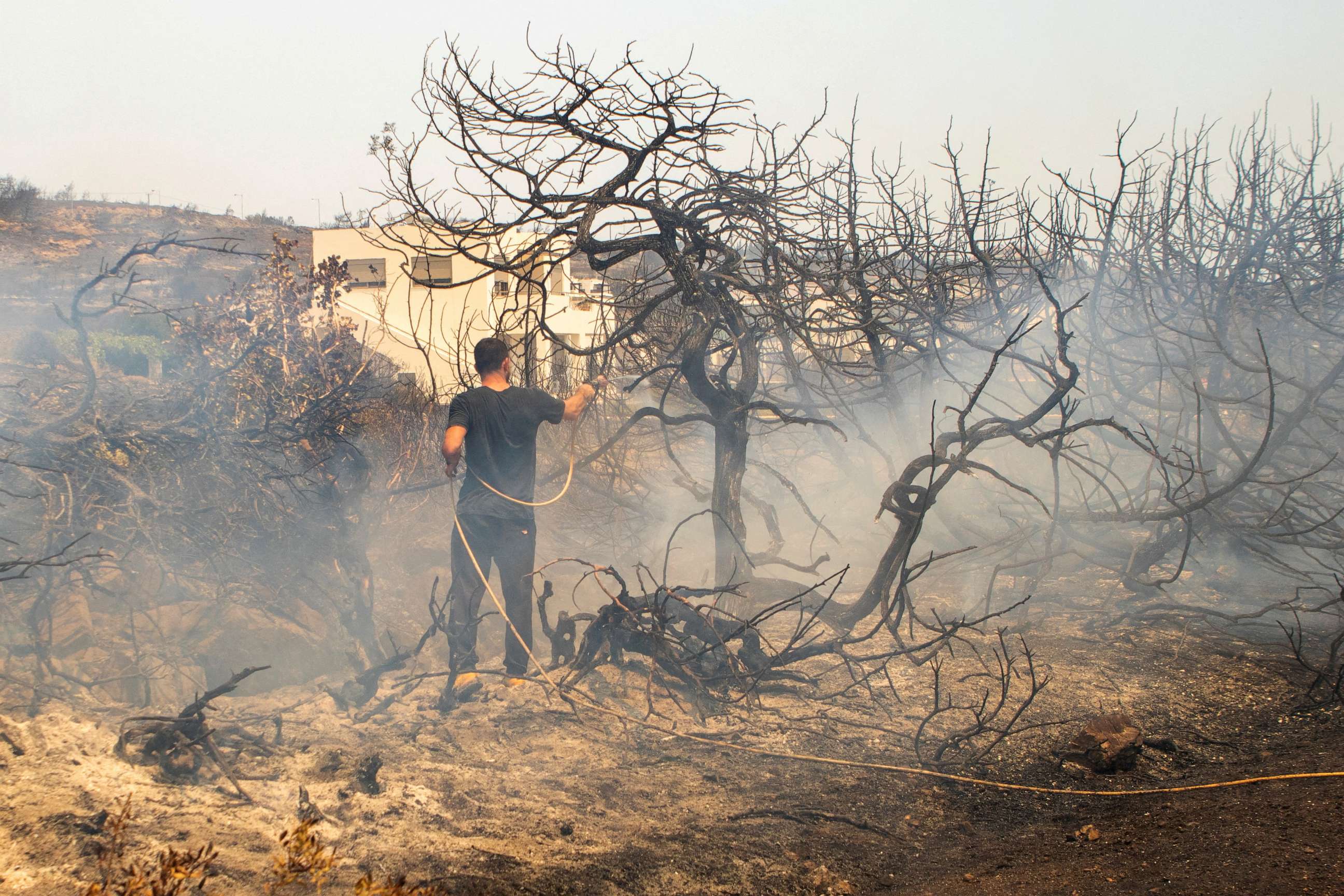PHOTO: A man tries to extinguish a wildfire burning at Kiotari, on the island of Rhodes, Greece, July 23, 2023.