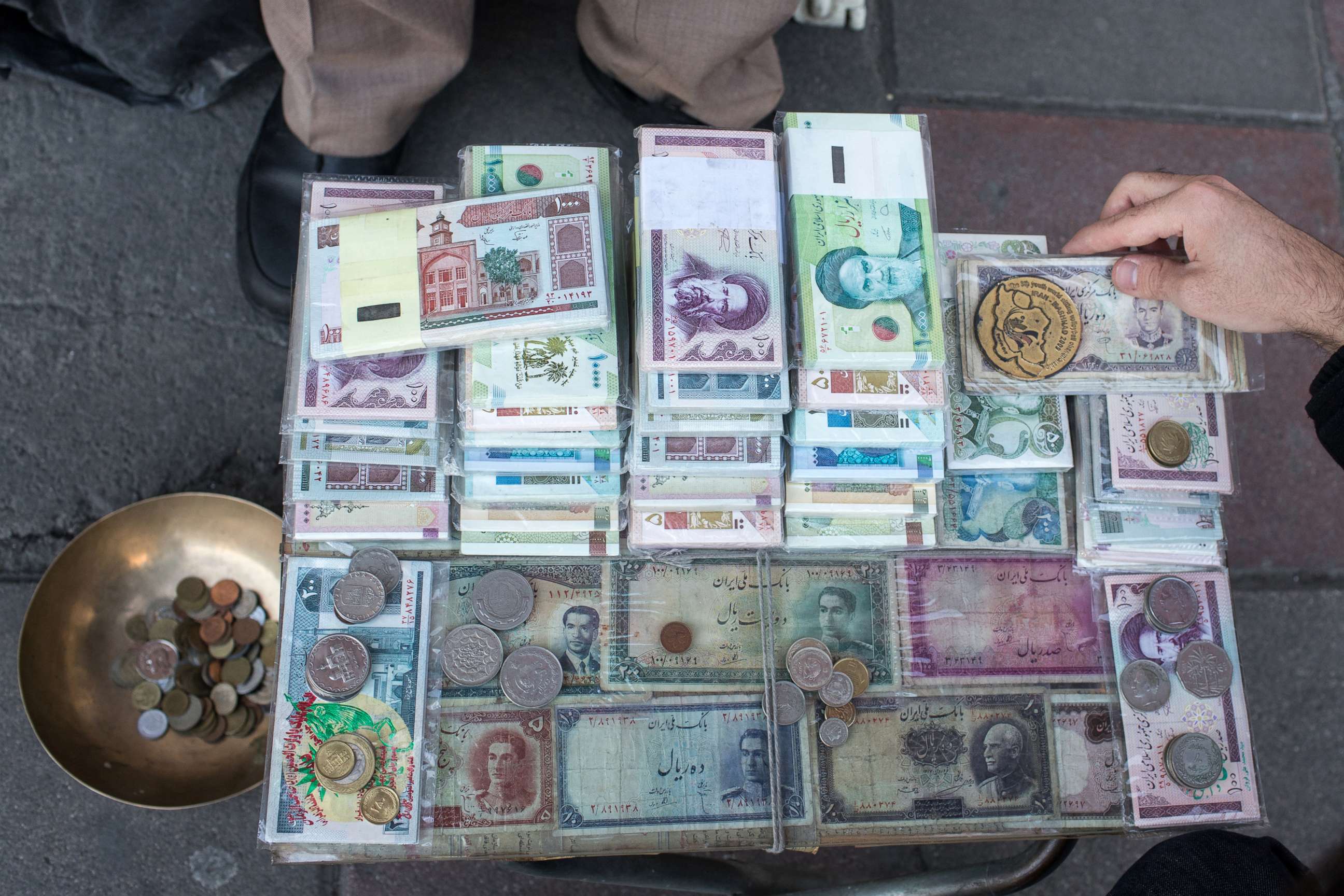 PHOTO: A dealer is seen selling different denominations of Iran's rials on a street in Tehran, Iran, Feb. 12, 2020. Iran's currency, the rial, will be replaced by a currency called the toman.