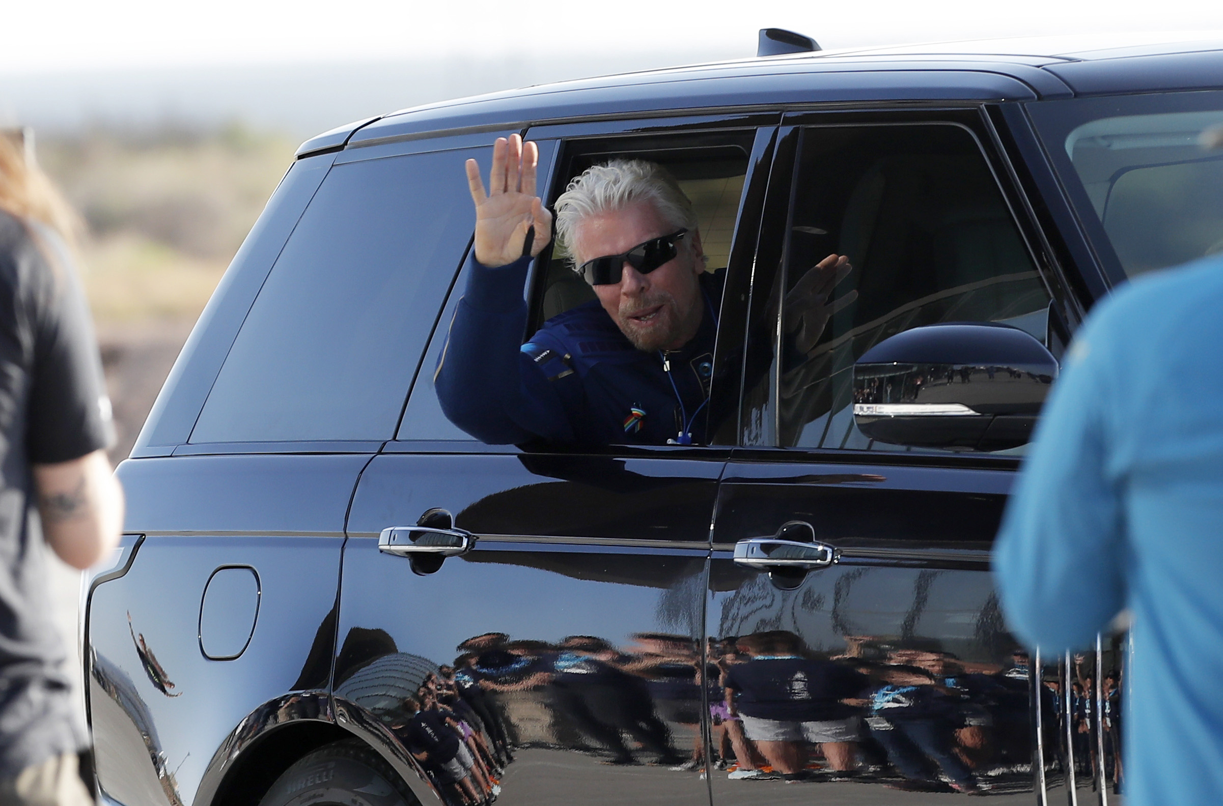 PHOTO: Virgin Galactic founder Richard Branson waves good bye while heading to board the rocket plane that will fly him to space from Spaceport America near Truth or Consequences, New Mexico, July 11, 2021.