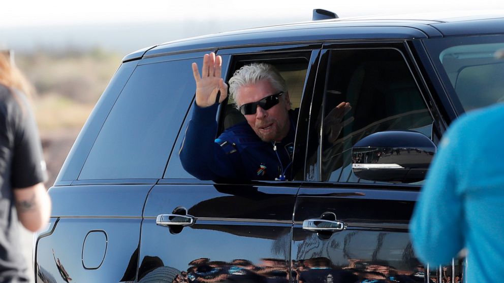 PHOTO: Virgin Galactic founder Richard Branson waves good bye while heading to board the rocket plane that will fly him to space from Spaceport America near Truth or Consequences, New Mexico, July 11, 2021.