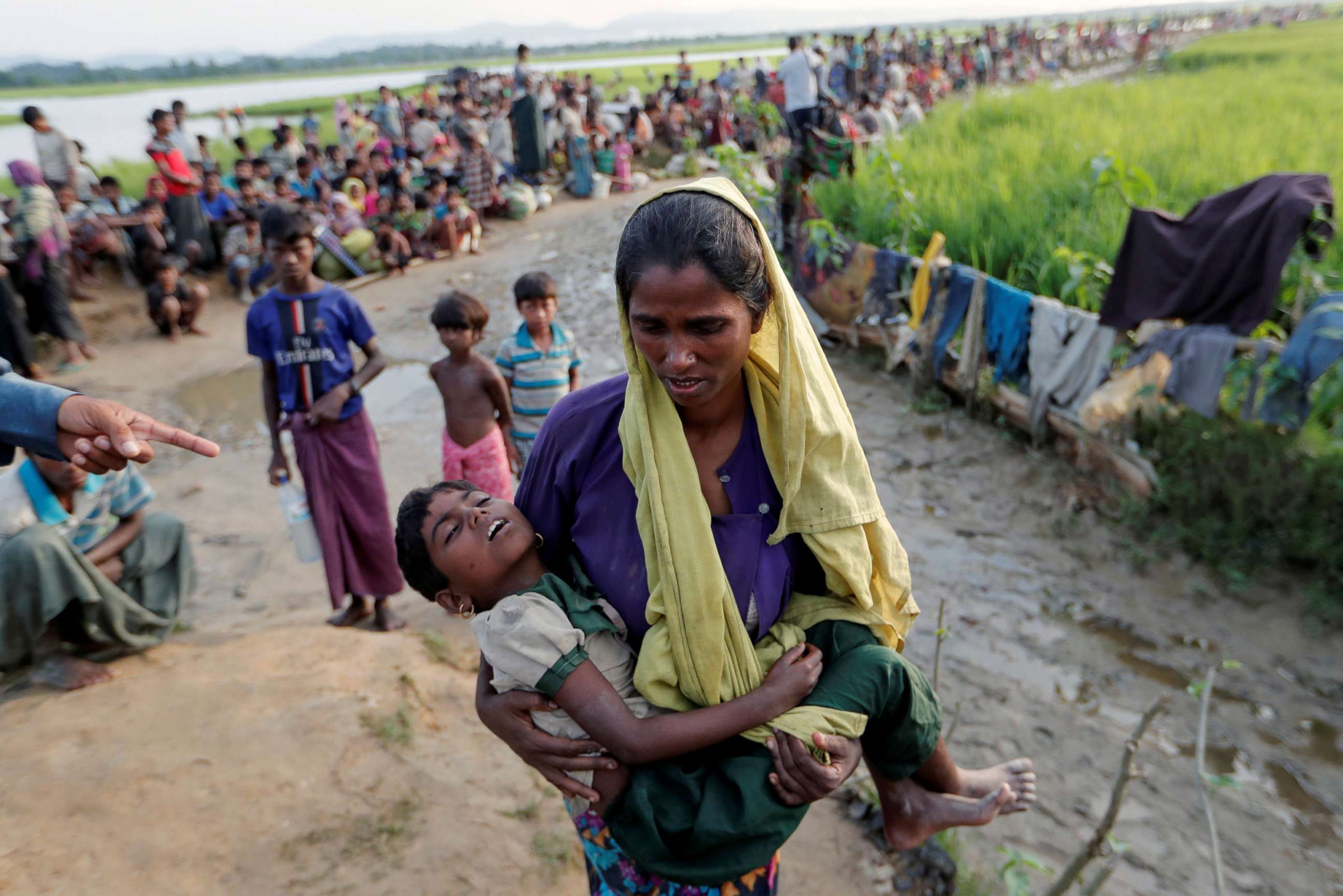 PHOTO: A Rohingya refugee woman who crossed the border from Myanmar a day before, carries her daughter as they wait to receive permission from the Bangladeshi army to continue to the refugee camps, in Palang Khali, Bangladesh, Oct. 17, 2017. 