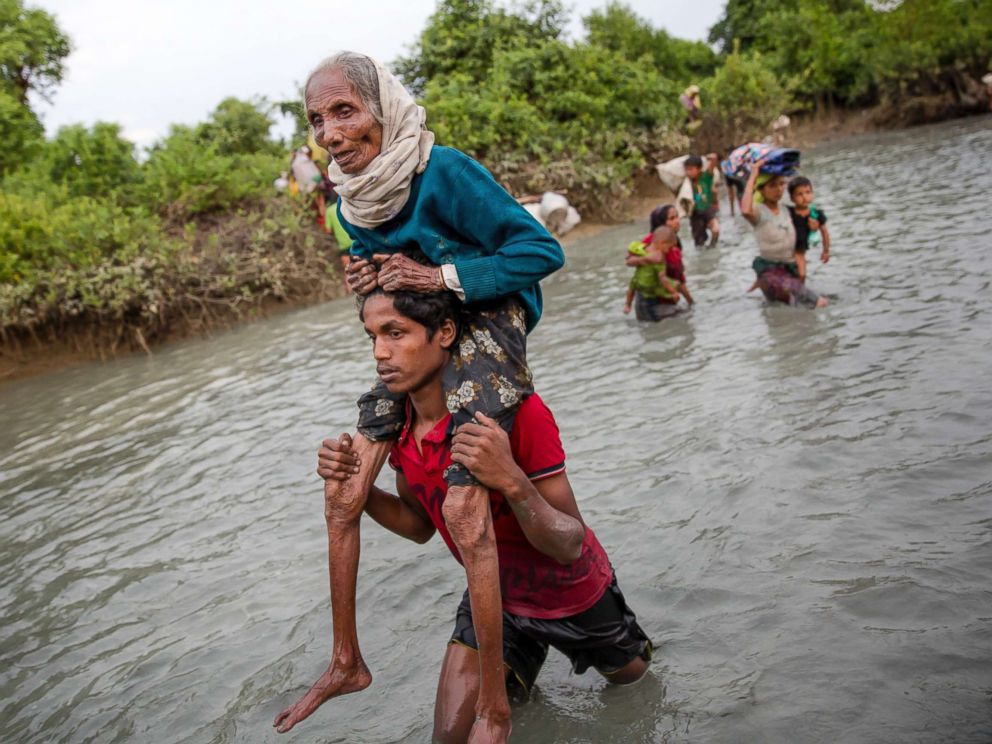 PHOTO: A Rohingya Muslim man carries an elderly woman through water after crossing the border from Myanmar into Bangladesh, near Palong Khali, Bangladesh on Nov. 1, 2017.