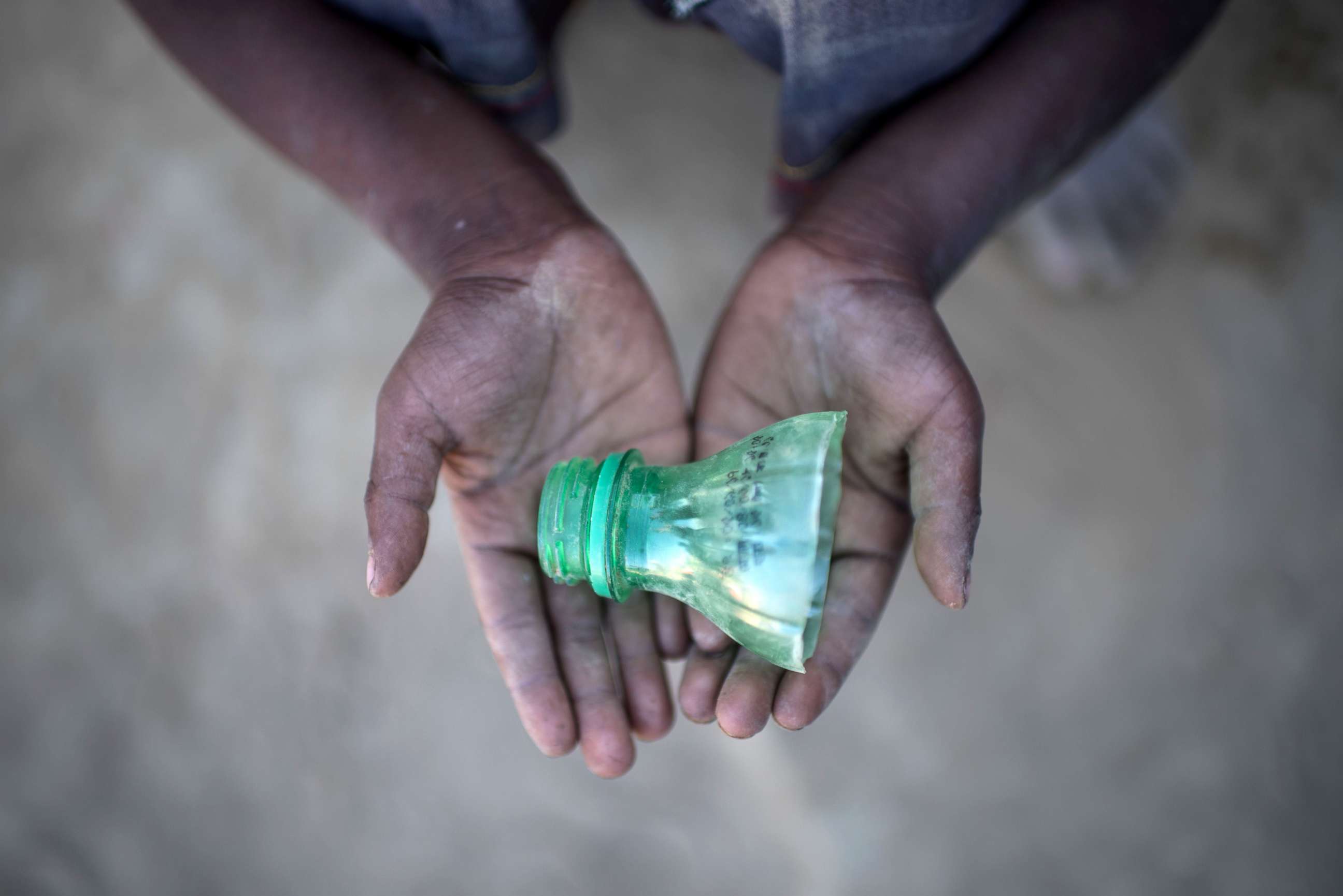 PHOTO: Rohingya migrant boy Shahidul Amin (5), who arrived in Bangladesh in September, holds a part of a bottle that he uses to play in the sand at the Thankhali refugee camp in Cox's Bazar, on Dec. 2, 2017. 