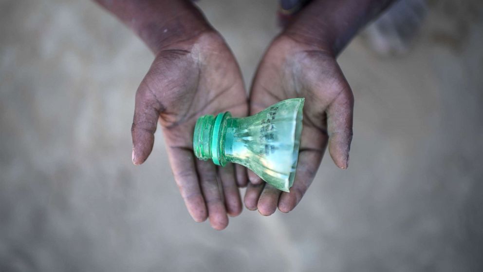 PHOTO: Rohingya migrant boy Shahidul Amin (5), who arrived in Bangladesh in September, holds a part of a bottle that he uses to play in the sand at the Thankhali refugee camp in Cox's Bazar, on Dec. 2, 2017. 