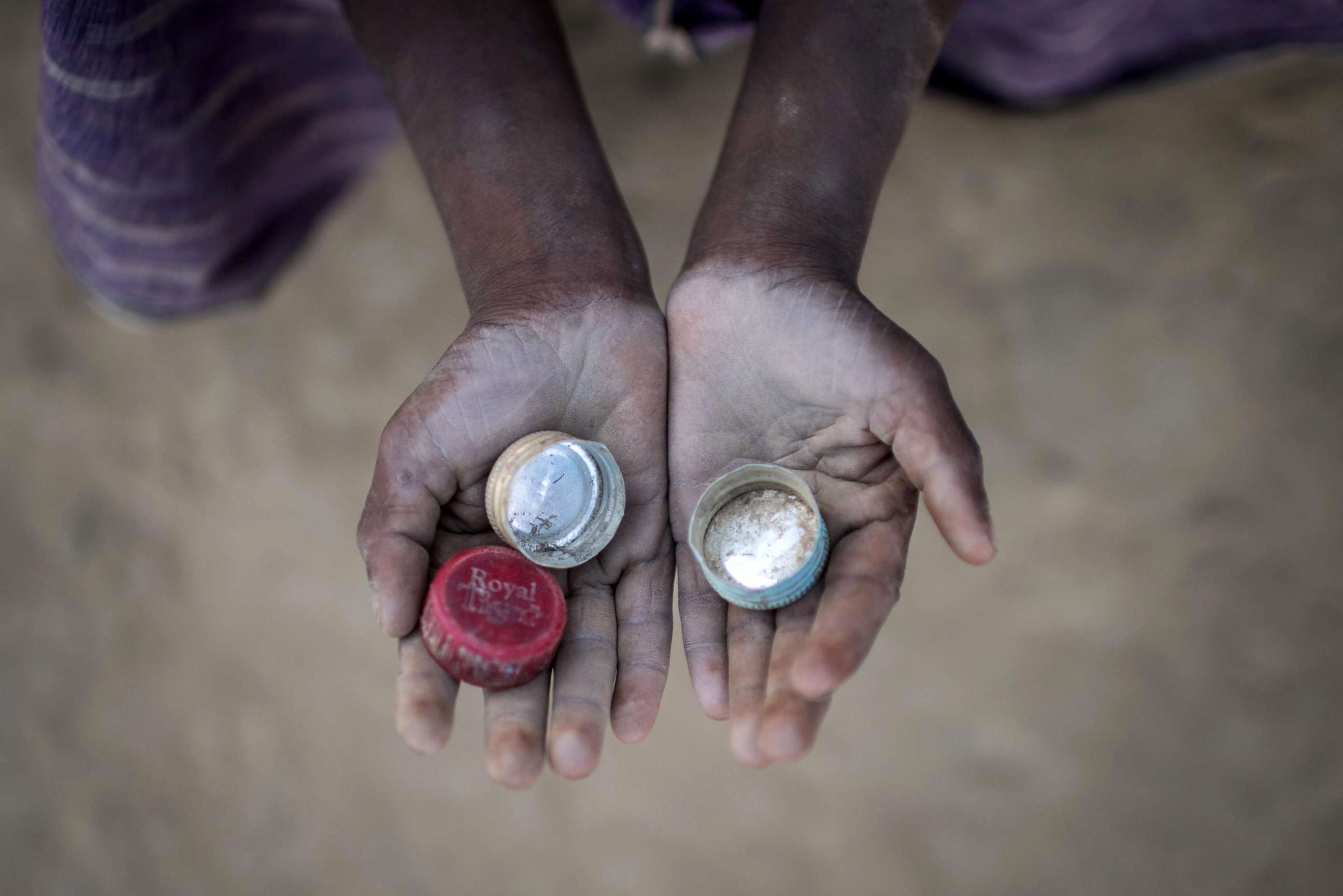 PHOTO: Rohingya migrant boy Abdul Hafez (5), who arrived in Bangladesh in September, holds bottle tops that he uses to play a game called 'Medakhela' at the Thankhali refugee camp in Cox's Bazar, Dec. 2, 2017. 
