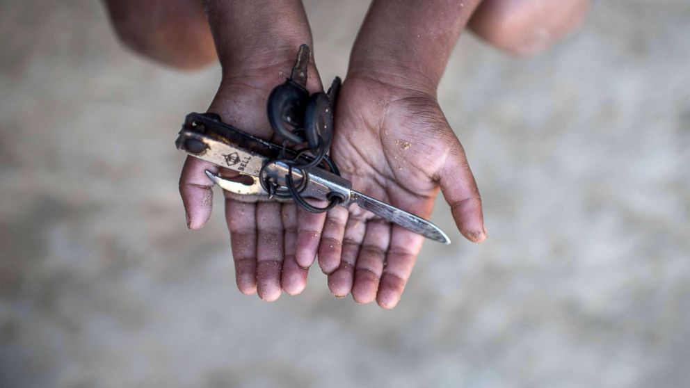 Rohingya migrant boy Warish Shah (3), who arrived in Bangladesh in September after his village was attacked, holds a pen knife with nail clippers that he plays with at the Thankhali refugee camp in Cox's Bazar, Dec. 2, 2017. 