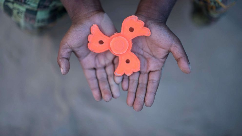 PHOTO: Rohingya migrant boy Mohammad Sadek (5) holds a plastic 'fidget spinner' that he found discarded, at Thankhali refugee camp in Cox's Bazar, Dec. 2, 2017. 