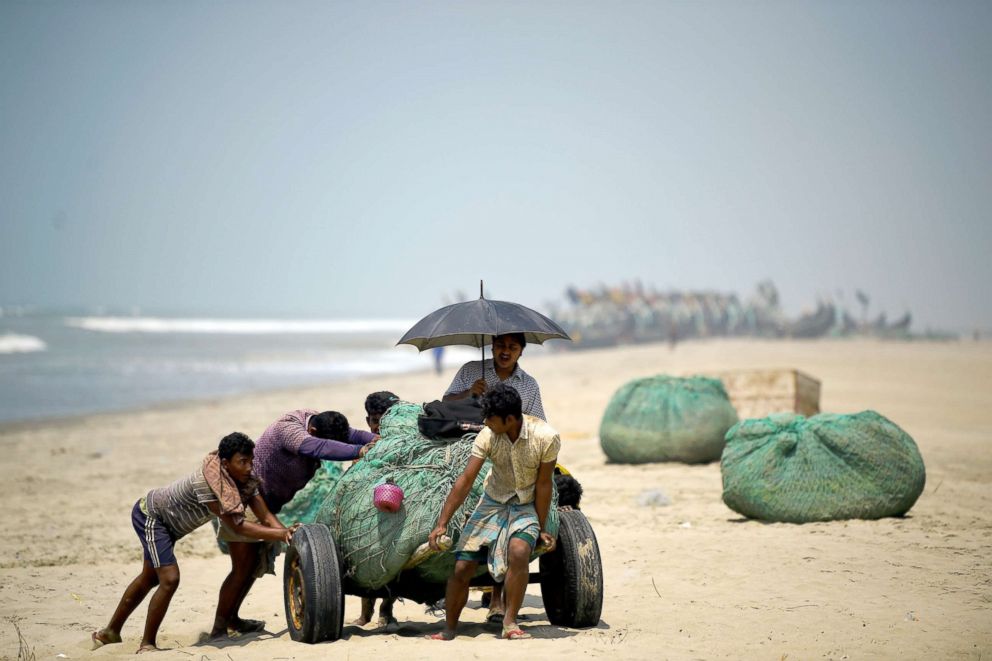 PHOTO: Rohingya refugees push fishing nets along the beach on Shamlapur beach in Cox's Bazaar, Bangladesh, March 22, 2018.