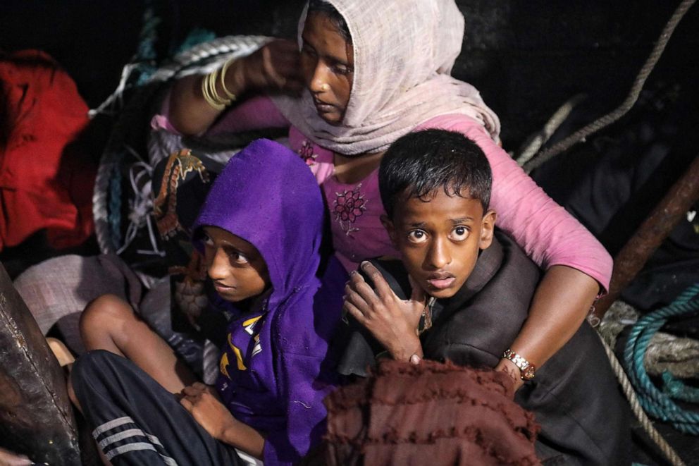 PHOTO: In this Dec. 31, 2021, file photo, Rohingya refugees sit on a wooden boat as Indonesian official conduct evacuation at the Krueng Geukueh port in Lhokseumawe, Aceh province after they were rescued by Indonesia's navy in the waters off Bireuen.