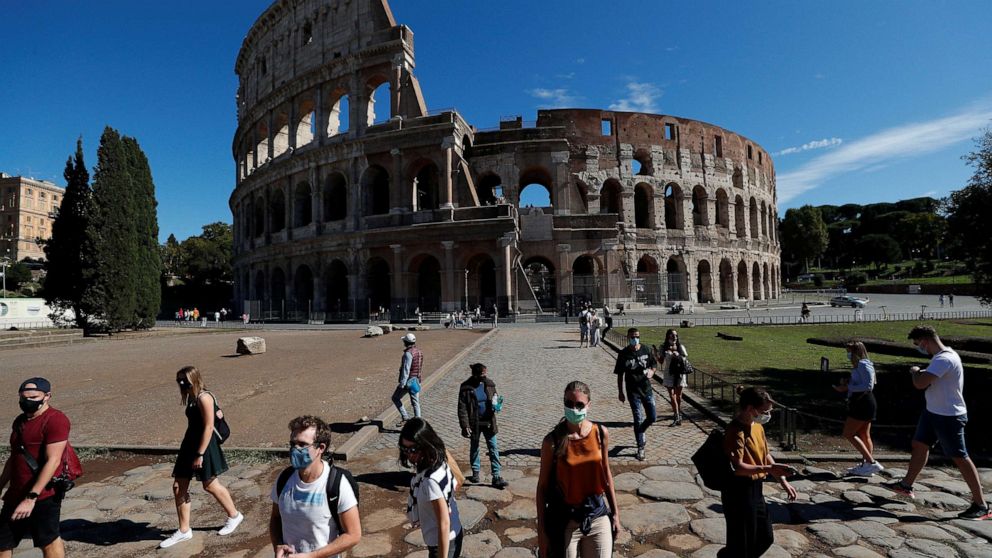 PHOTO:People wear protective face masks walk past the Colosseum as local authorities in the Italian capital Rome ordered face coverings to be worn at all times outdoors, in an effort to counter the spread of the coronavirus disease in Rome, Oct. 8, 2020.