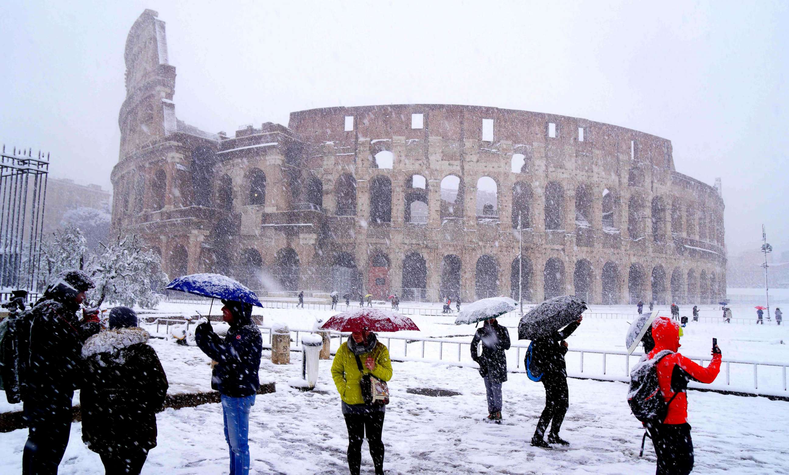 PHOTO: Tourists take pictures of the ancient Colosseum during a snowfall in Rome, Feb. 26, 2018.