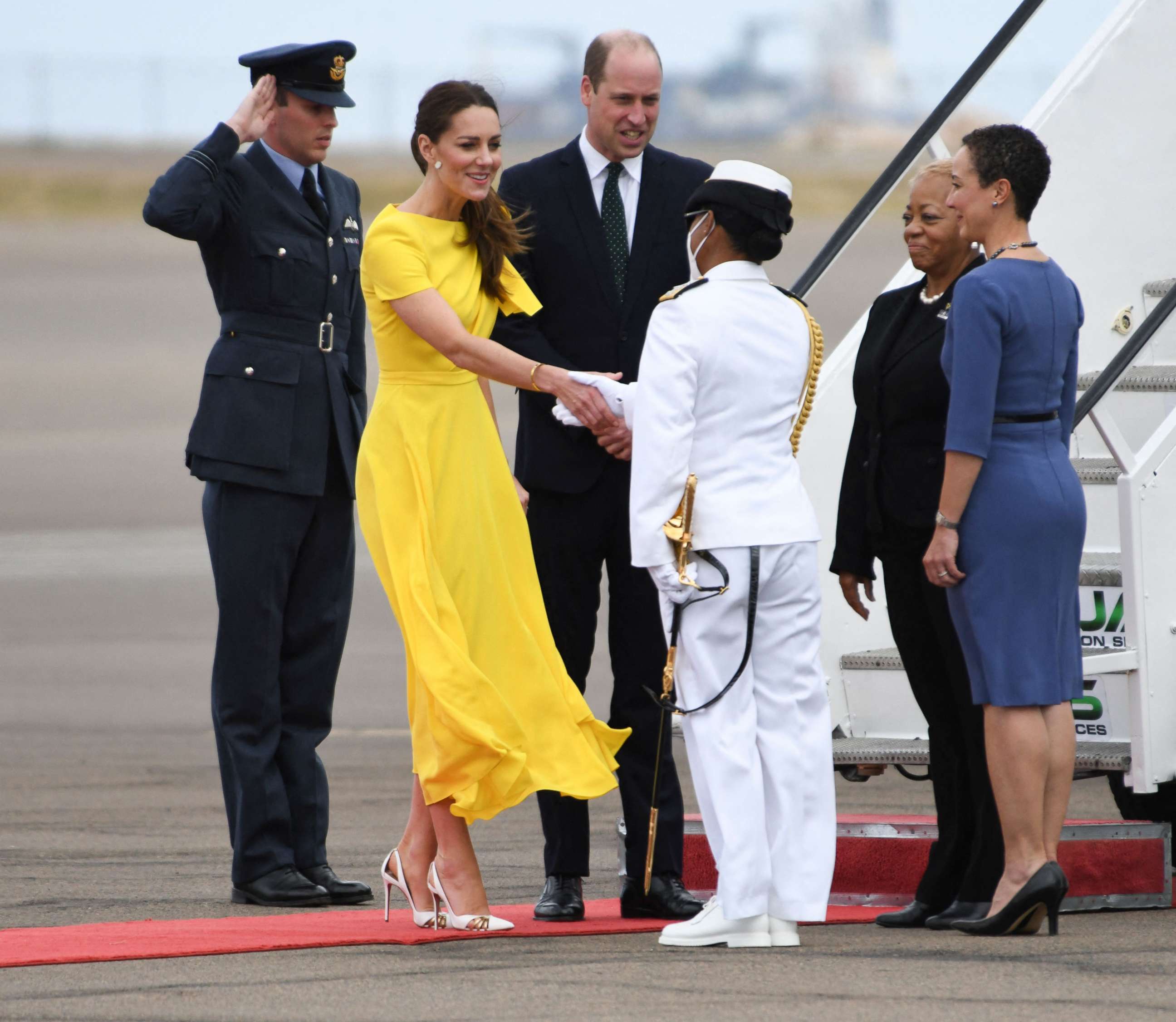 PHOTO: Prince William, Duke of Cambridge and his wife Catherine, Duchess of Cambridge, are greeted by officials upon arrival in Jamaica on March 22, 2022.