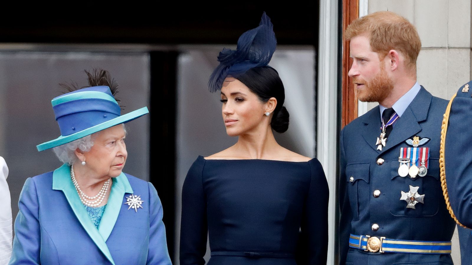 PHOTO: Queen Elizabeth II, Meghan, Duchess of Sussex and Prince Harry, Duke of Sussex watch a flypast to mark the centenary of the Royal Air Force from the balcony of Buckingham Palace, July 10, 2018, in London.