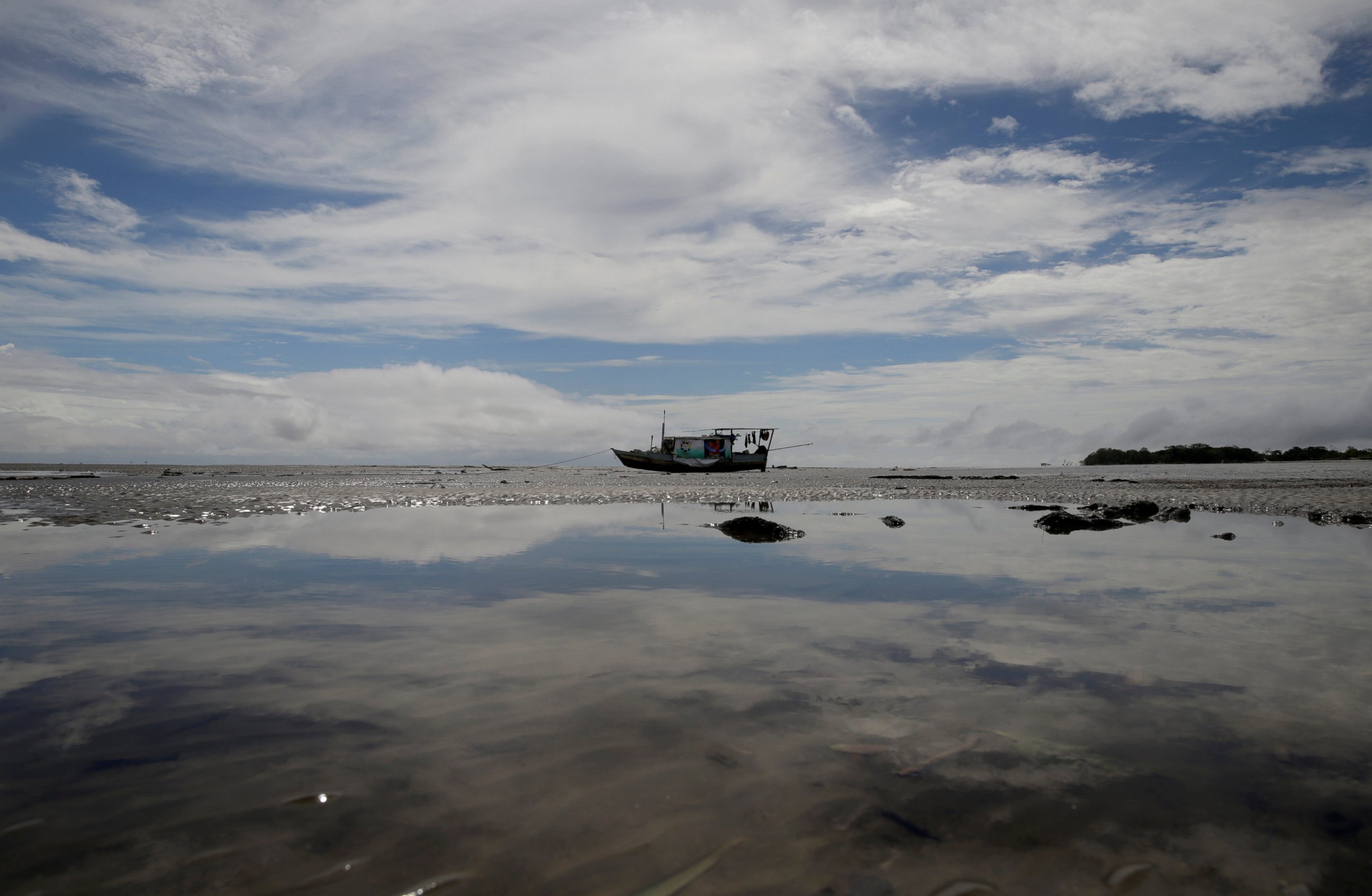PHOTO: A boat stands during low tide at the mouth of the Calcoene River where it joins the Atlantic Ocean on the coast of Amapa state, northern Brazil, April 6, 2017. 