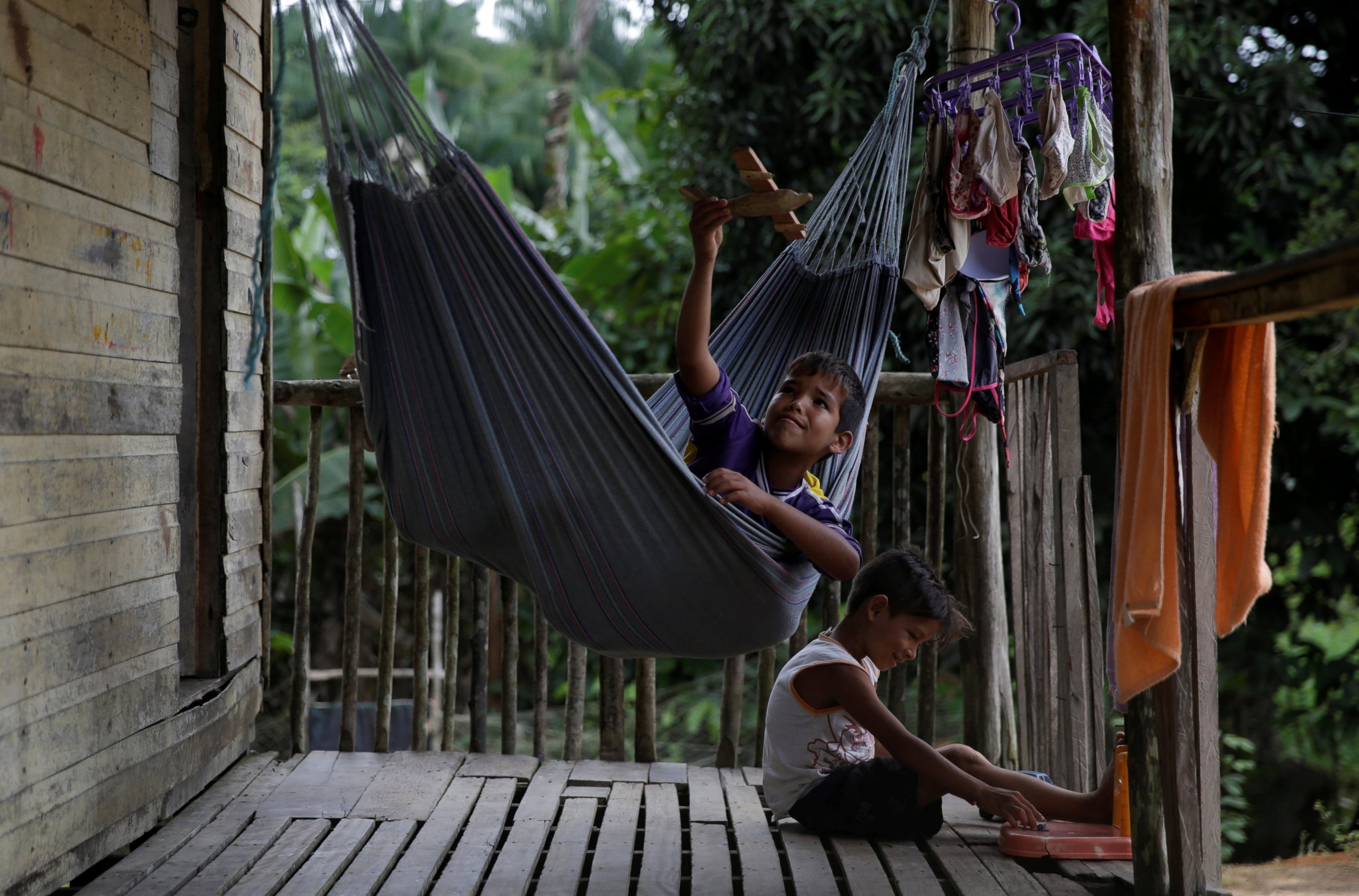 PHOTO: Marcos Paulo, an indigenous boy from the Karipuna tribe, plays in a hammock on the deck of his house on the banks of the Oiapoque River on the coast of Amapa state, near Oiapoque city, northern Brazil, April 4, 2017. 
