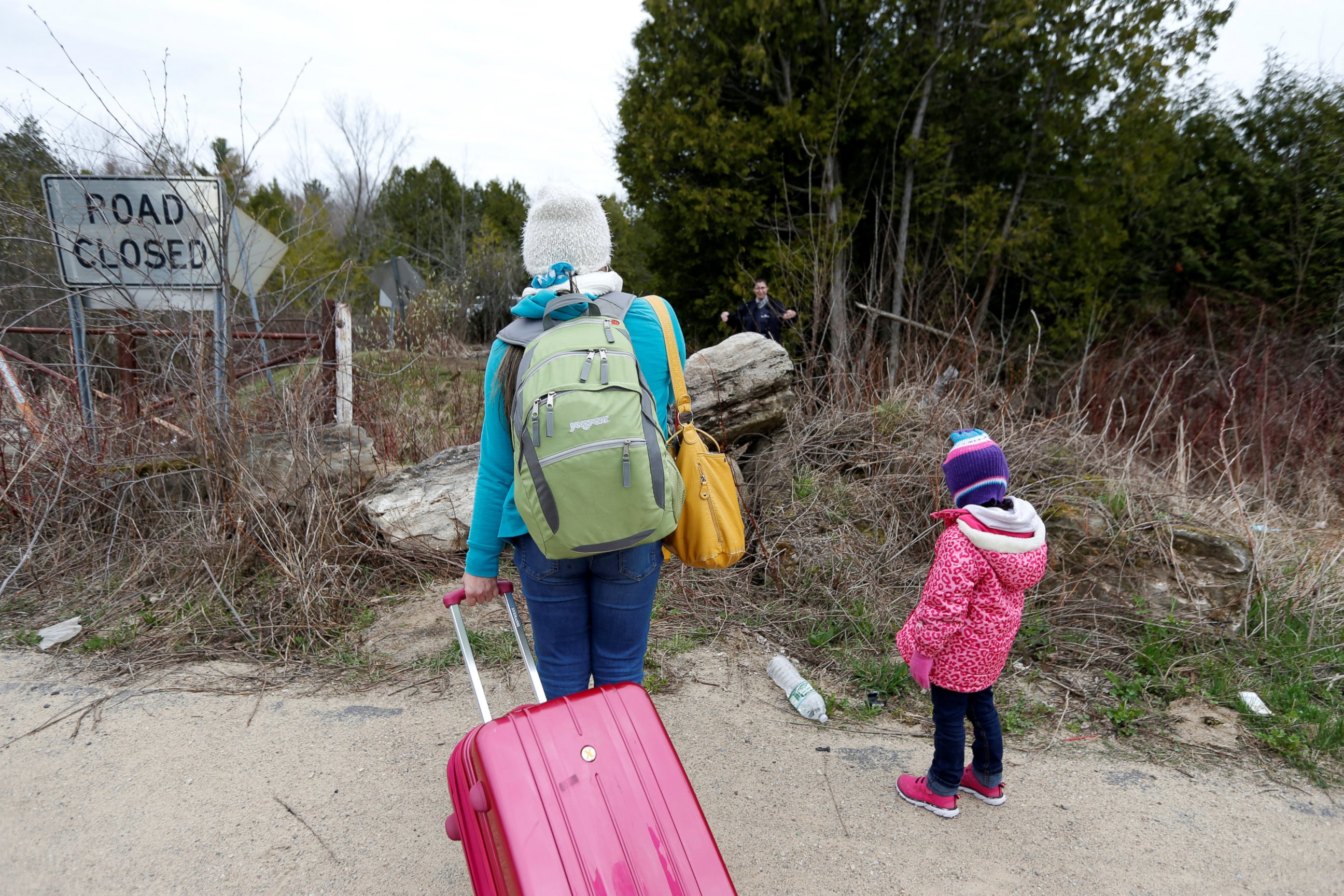PHOTO: A mother and child are confronted by a Royal Canadian Mounted Police (RCMP) officer as they approach the U.S.-Canada border on Roxham Road in Champlain, New York, April 24, 2017.
