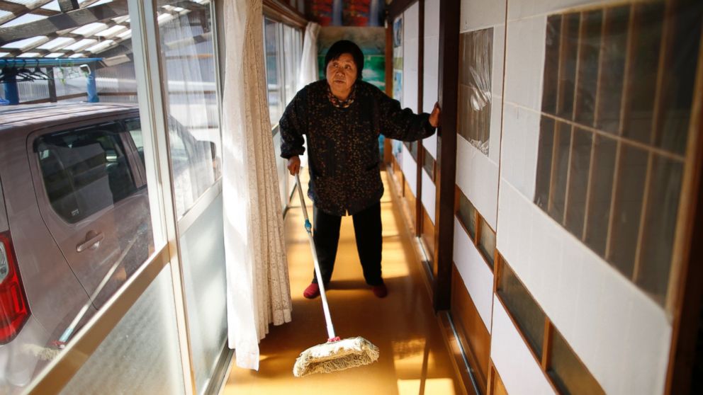 Kimiko Koyama, 69, who evacuated from the Miyakoji area of Tamura three years ago, dusts off her house after she returned to her home with her husband Toshio, 76, in Tamura, Fukushima prefecture, April 1, 2014. 