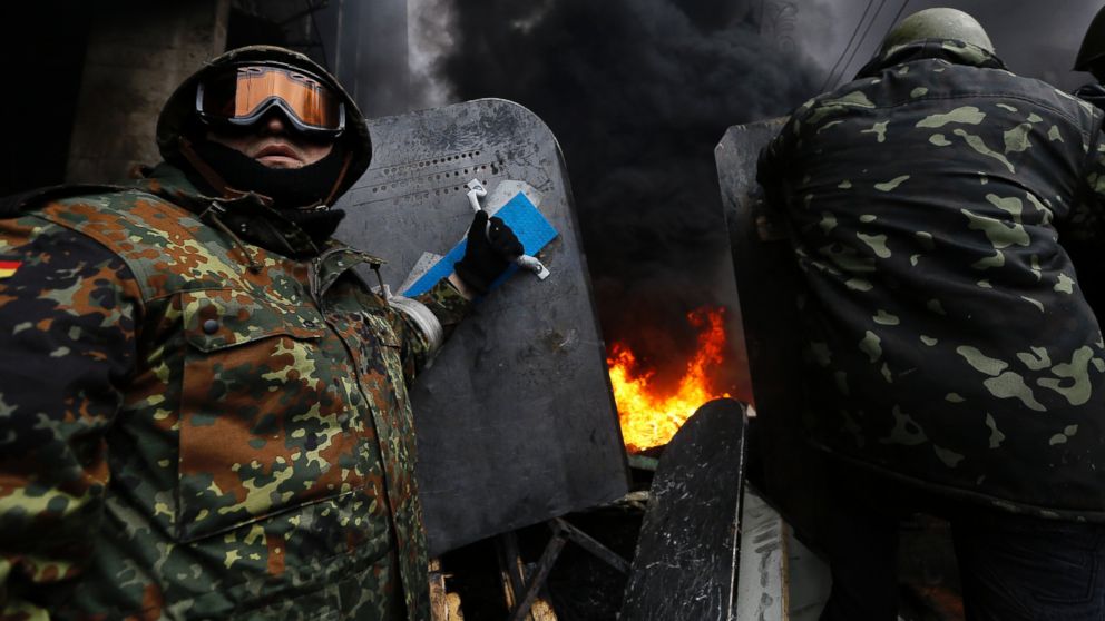 Anti-government protesters prepare to advance over a burning barricade in Kiev's Independence Square, Feb. 20, 2014. 