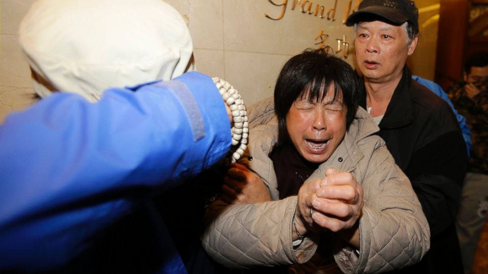 A family member of a passenger aboard Malaysia Airlines flight 370 cries after watching a television broadcast of a news conference, at the Lido hotel in Beijing, March 24, 2014. 
