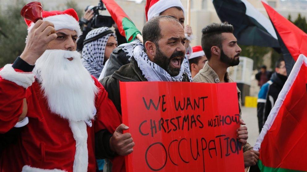 PHOTO: A Palestinian protestors demonstrate against Israeli settlements during Christmas, near a checkpoint in the West Bank city of Bethlehem, Dec. 23, 2014. 