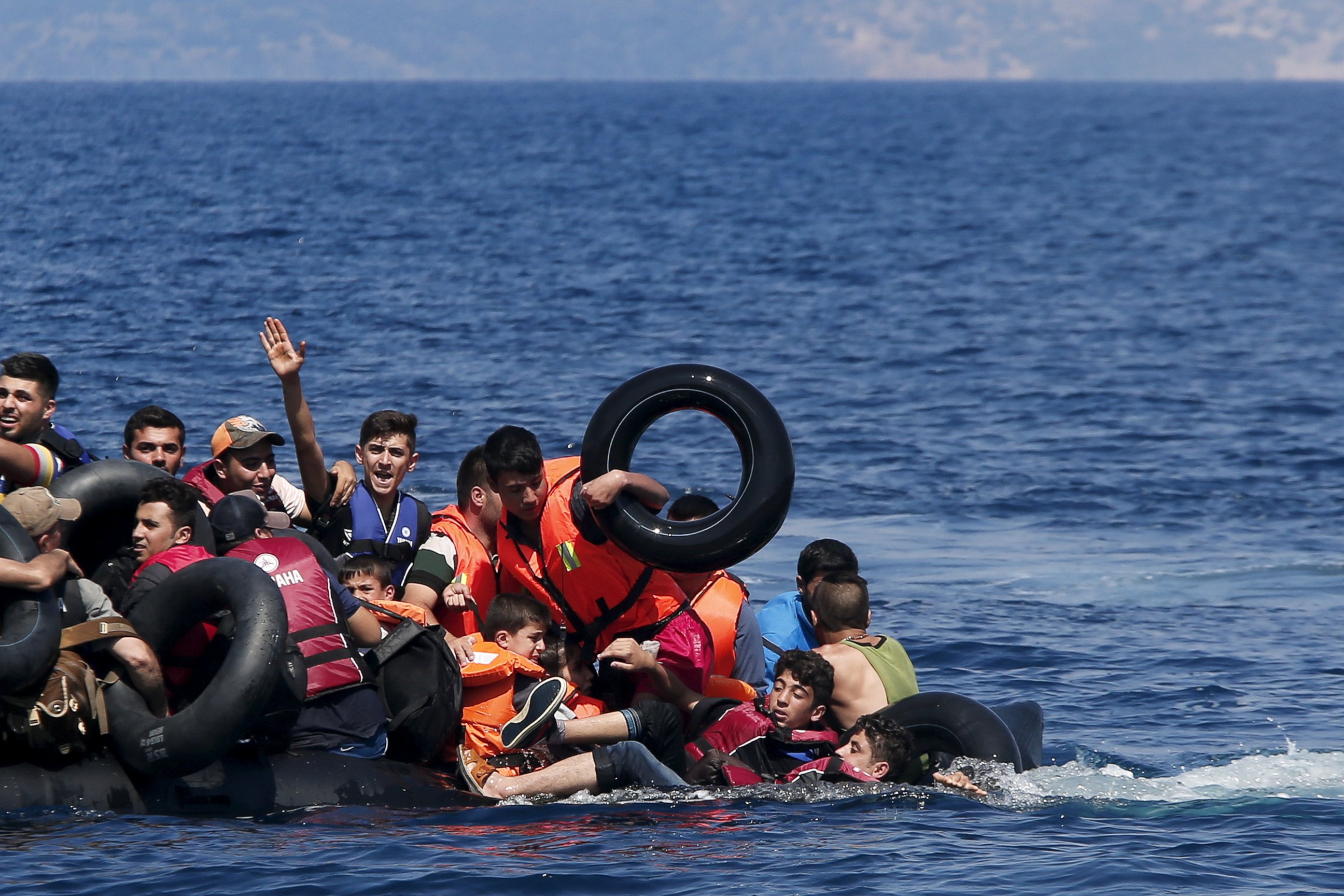 PHOTO: Syrian and Afghan refugees fall into the sea after their dinghy deflated before reaching the Greek island of Lesbos, Sept. 13, 2015.