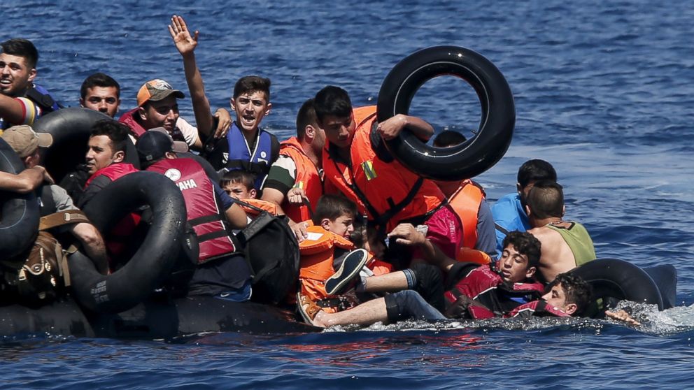 PHOTO: Syrian and Afghan refugees fall into the sea after their dinghy deflated before reaching the Greek island of Lesbos, Sept. 13, 2015.
