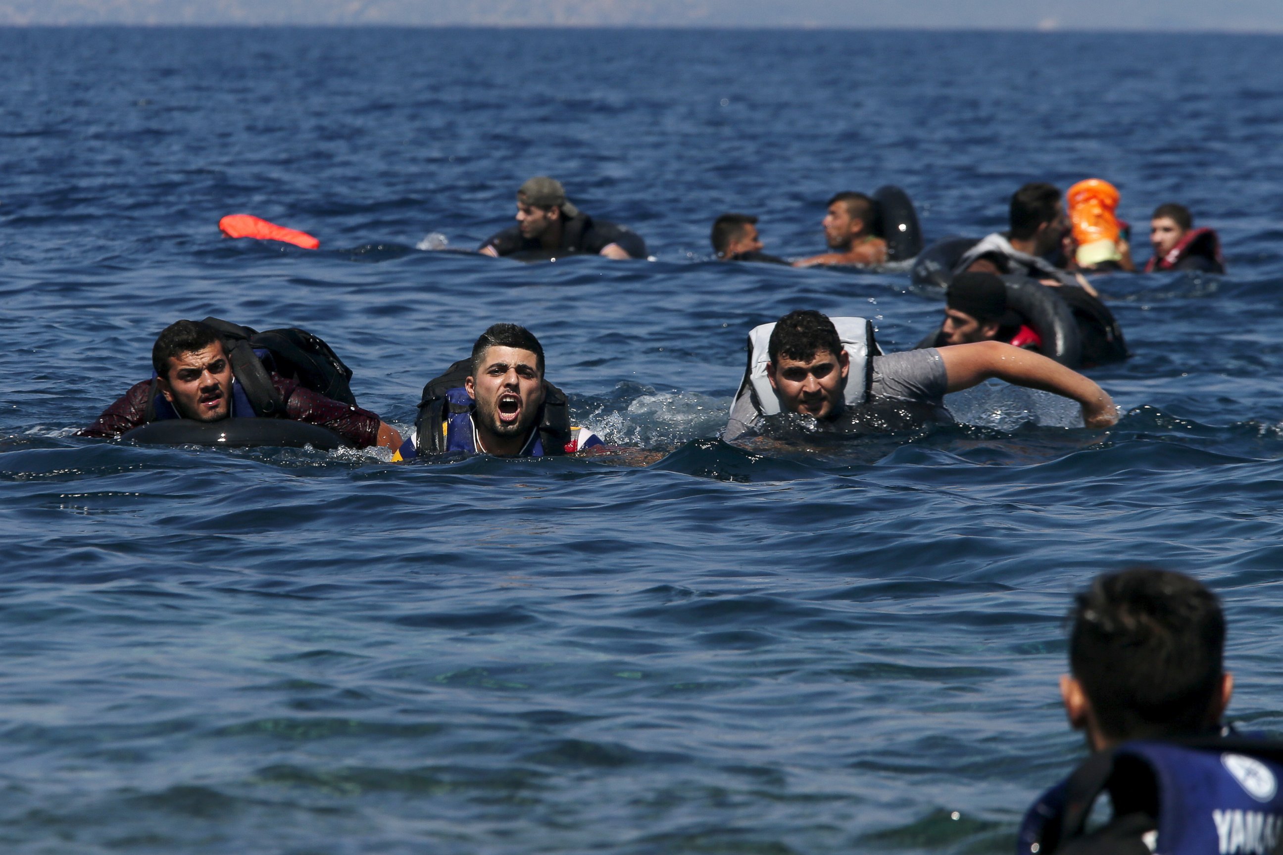 PHOTO: A refugee shouts as he swims towards the shore after a dinghy carrying Syrian and Afghan refugees deflated about 100 meters before reaching the Greek island of Lesbos, Sept. 13, 2015.