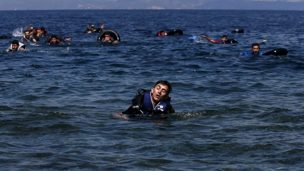 A refugee appears exhausted while swimming towards the shore after a dinghy carrying Syrian and Afghan refugees deflated about 100 meters before reaching the Greek island of Lesbos, Sept. 13, 2015.