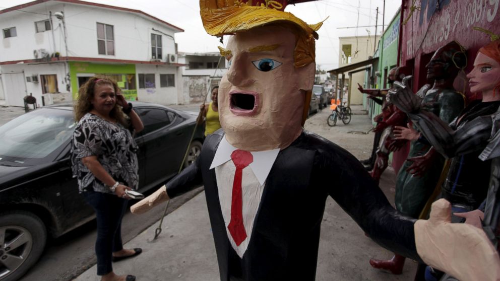 A Mexican client who lives in the U.S., looks at a pinata depicting U.S. Republican presidential candidate Donald Trump hanging outside a workshop in Reynosa, Mexico, June 23, 2015. 