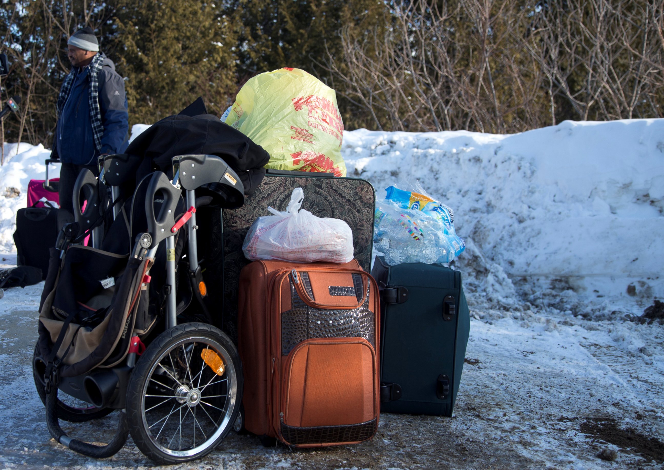 PHOTO: A man claiming to be from Sudan is detained with his family's luggage by a U.S. border patrol officer after his family crossed the U.S.-Canada border into Hemmingford, Canada, from Champlain in New York, Feb. 17, 2017.