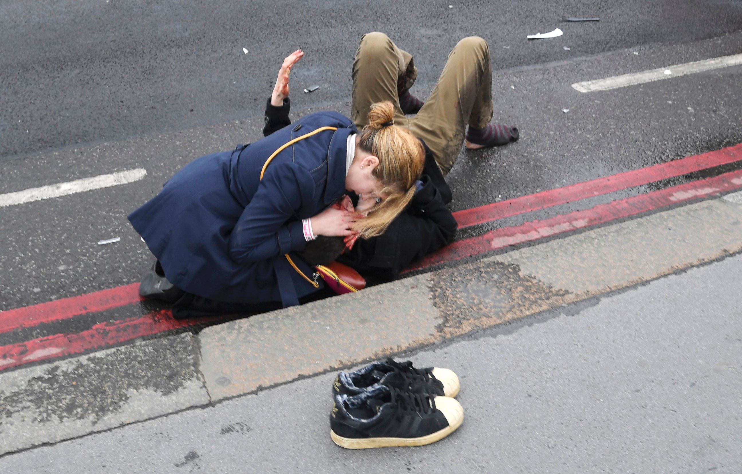 PHOTO: A woman assists an injured person after an incident on Westminster Bridge in London, March 22, 2017.