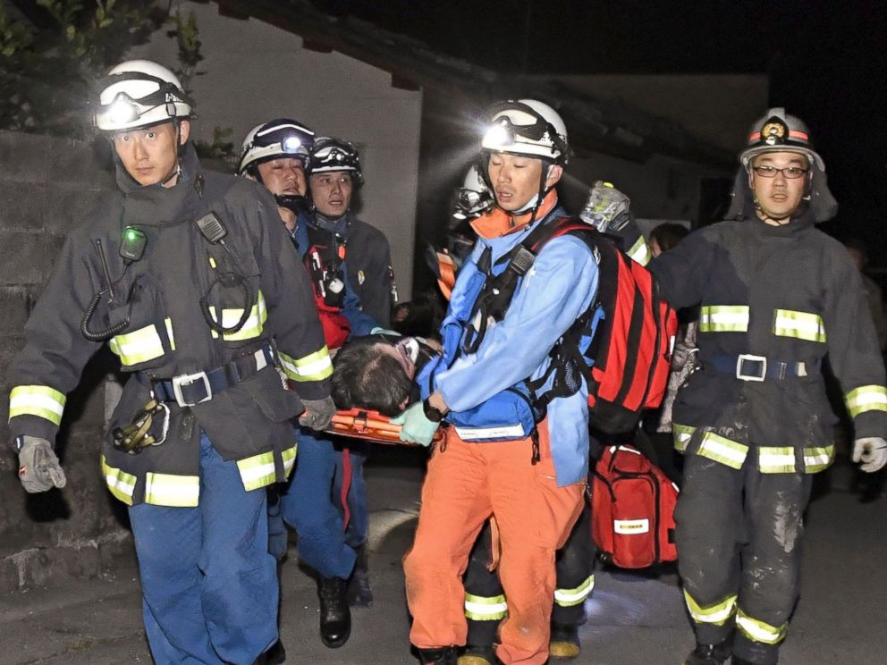 PHOTO: Rescue workers use a stretcher to carry a man who was rescued from a collapsed house in Mashiki town, Kumamoto prefecture, southern Japan, April 15, 2016.