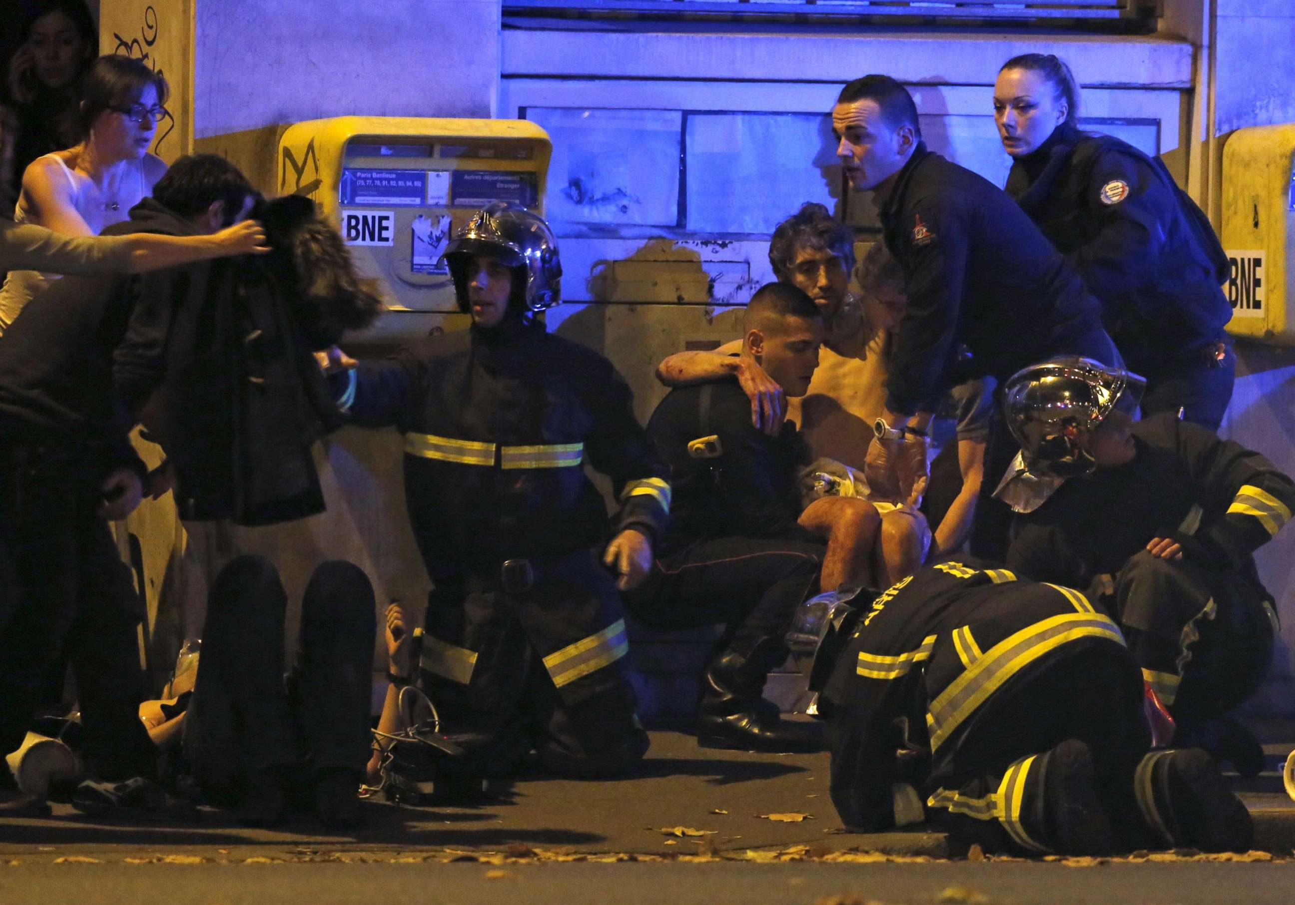 PHOTO: French fire brigade members aid an injured individual near the Bataclan concert hall following fatal shootings in Paris, Nov. 13, 2015.