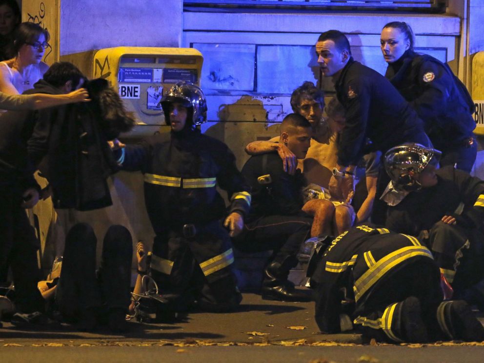 PHOTO: French fire brigade members aid an injured individual near the Bataclan concert hall following fatal shootings in Paris, Nov. 13, 2015.
