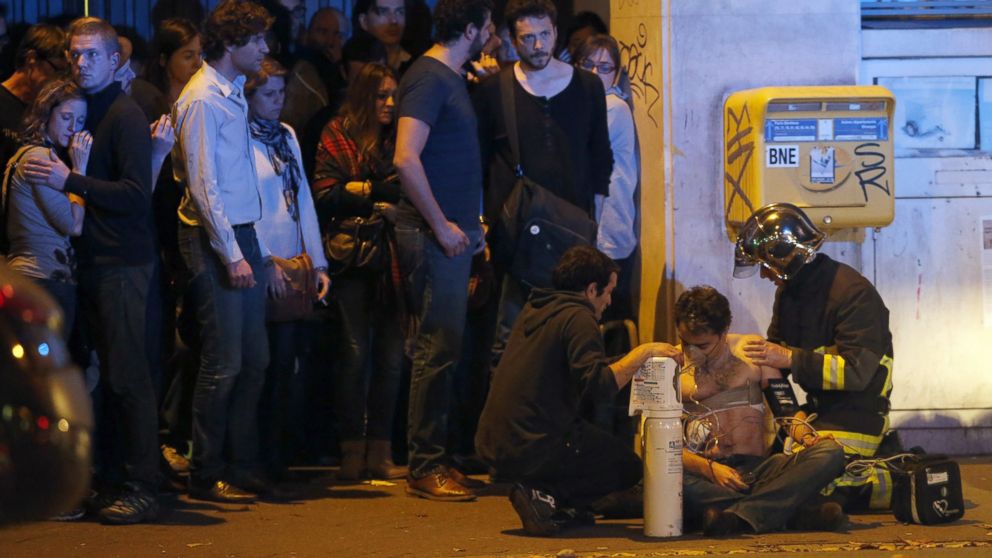 PHOTO: A member of the French fire brigade aids an injured individual near the Bataclan concert hall following fatal shootings in Paris, Nov. 13, 2015.