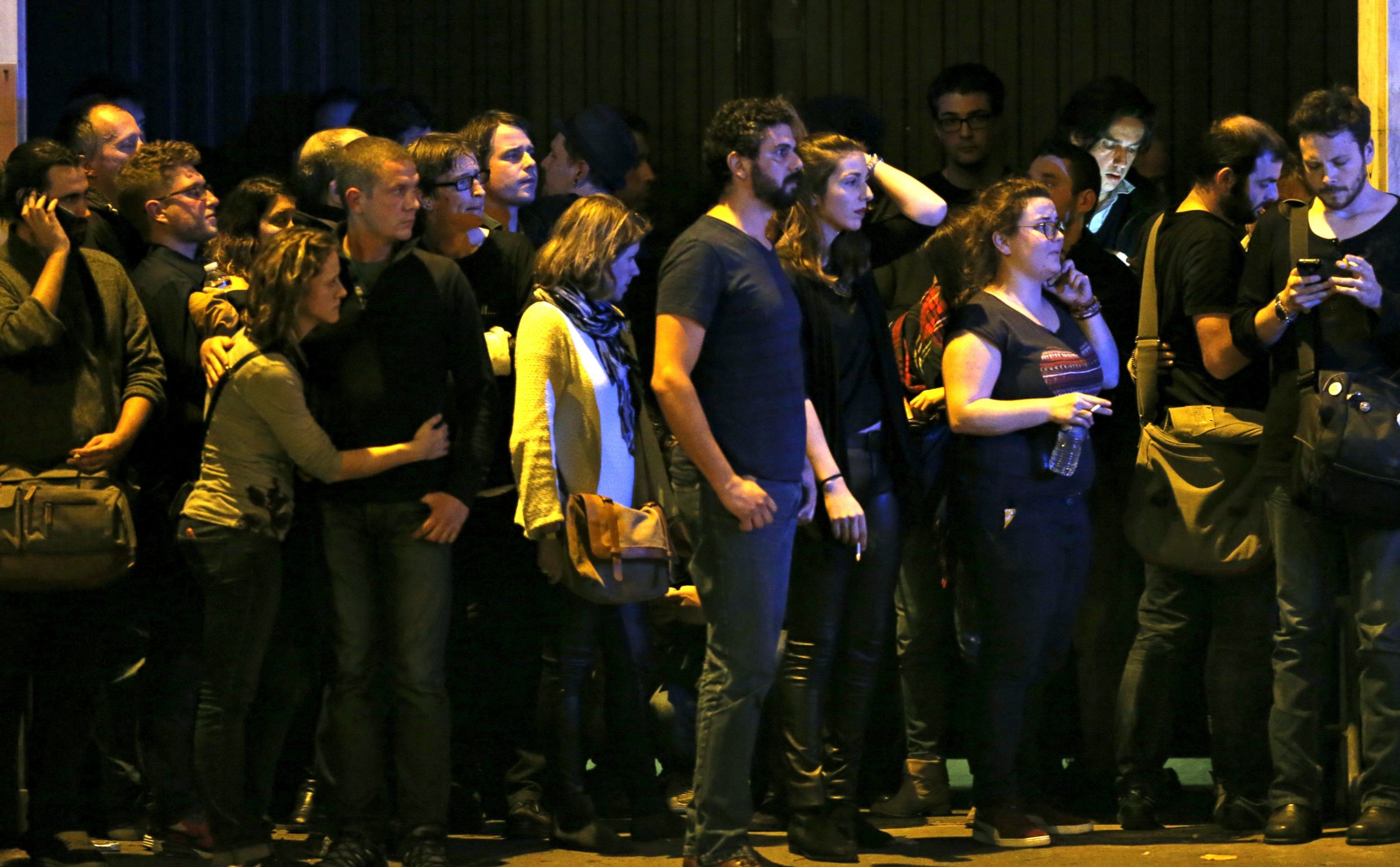 PHOTO: People react as they gather to watch the scene near the Bataclan concert hall following fatal shootings in Paris, France, Nov. 13, 2015.