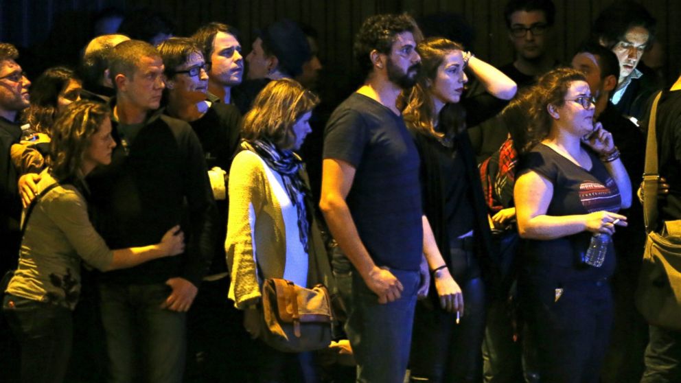 PHOTO: People react as they gather to watch the scene near the Bataclan concert hall following fatal shootings in Paris, France, Nov. 13, 2015.