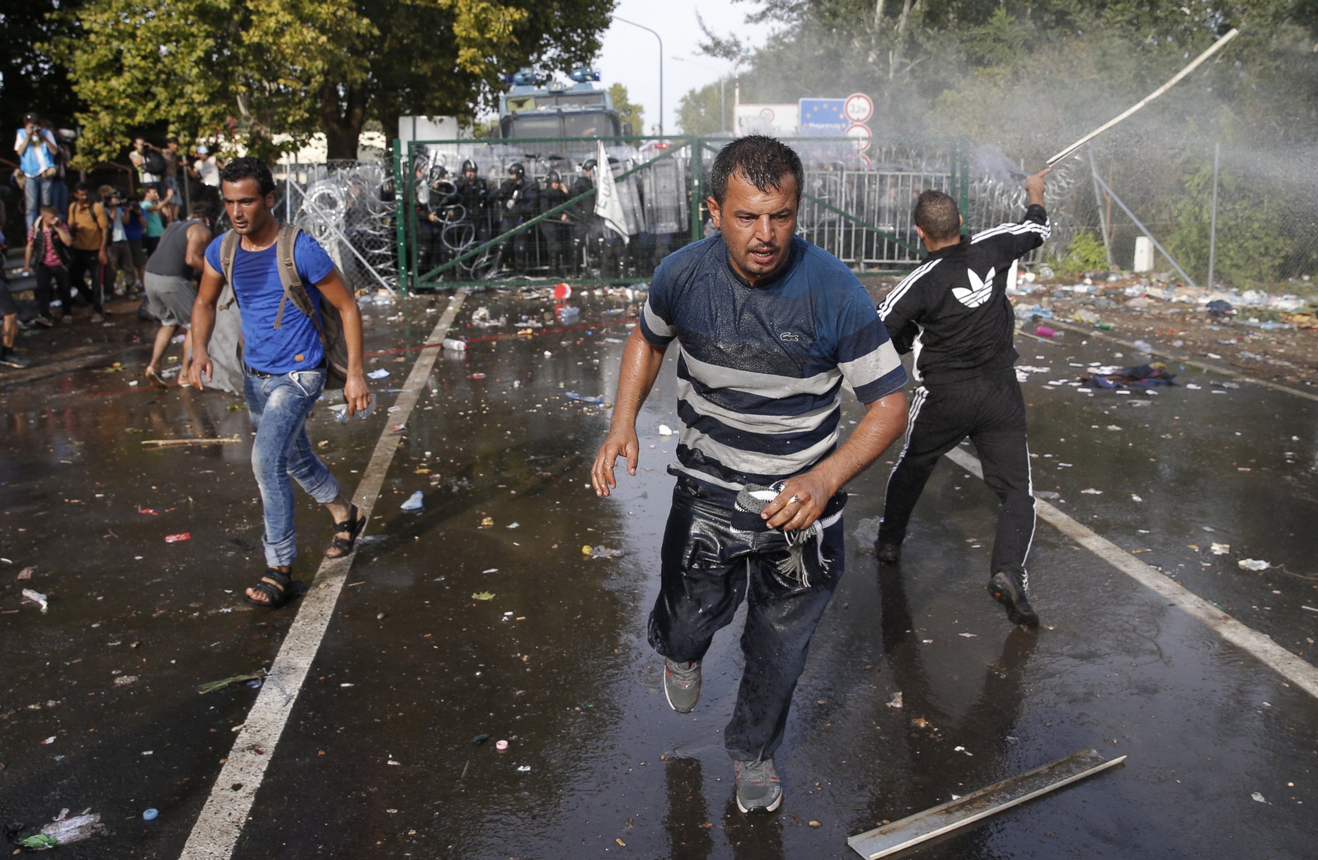 PHOTO: Migrants run as Hungarian riot police fires tear gas and water cannon at the border crossing with Serbia in Roszke, Hungary, Sept. 16, 2015.